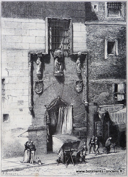 Dans une rue de Madrid, la porte d'entrée de l'hôpital de la Latina décorée de blasons et de statues. Des rideaux ferment partiellement la porte constituée d'un imposant arc brisé. P1270421.jpg